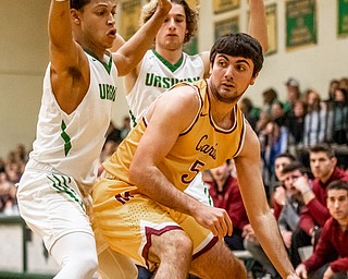 DIANNA OATRIDGE | THE VINDICATOR Cardinal Mooney's Pete Haas (5) drives the baseline under defensive pressure from Ursuline's Devan Keevey (left) and Vince Armeni (right) during Friday's game at Ursuline High School Gymnasium.