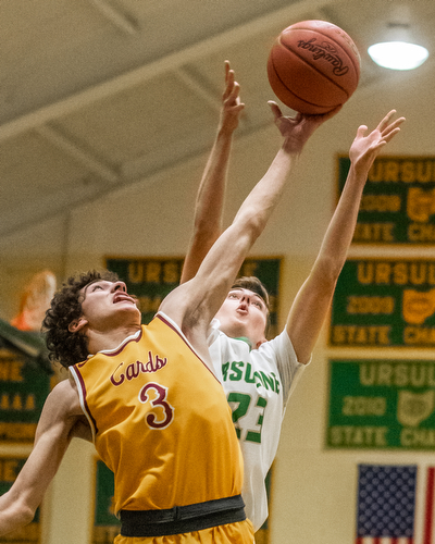 DIANNA OATRIDGE | THE VINDICATOR Cardinal Mooney's Sonny Rodriguez (3) and Ursuline's Johnny Rowland (23) reach for a rebound during Friday's  game at Ursuline High School.