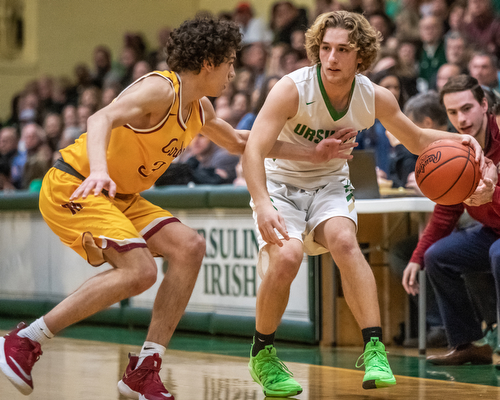 DIANNA OATRIDGE | THE VINDICATOR Ursuline's Vince Armeni (right) dribbles against pressure from Cardinal Mooney's Sonny Rodriguez (left) during their game at Ursuline High School on Friday.