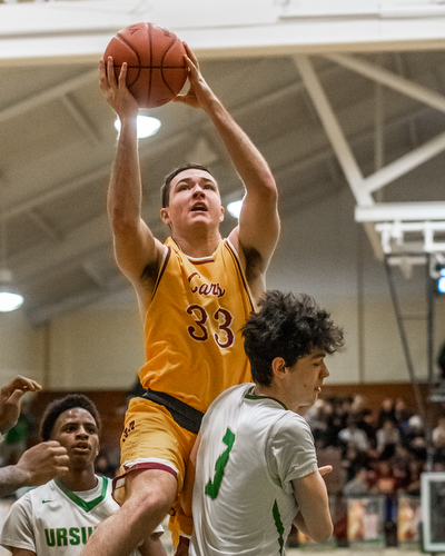 DIANNA OATRIDGE | THE VINDICATOR Cardinal Mooney's John Murphy (33) drives to the hoop over Ursuline's Pat McLaughlin (3) during Friday's game at Ursuline High School.