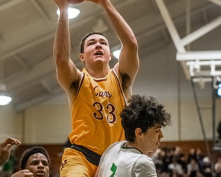 DIANNA OATRIDGE | THE VINDICATOR Cardinal Mooney's John Murphy (33) drives to the hoop over Ursuline's Pat McLaughlin (3) during Friday's game at Ursuline High School.