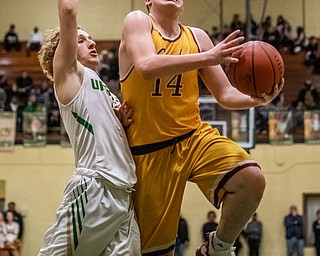 DIANNA OATRIDGE | THE VINDICATOR Cardinal Mooney's Mike Pelini (14) drives to the basket as Ursuline's Vince Armeni (4) defends during Friday's game at Ursuline High School.