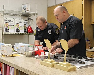 Neighbors | Abby Slanker.Canfield High School Resource Officer Steve Garstka (left) and Associate Athletic Director Mike Cochran looked over the mini cardboard food trucks students created as they served as judges for Angela Alexandrides’ Culinary Arts class final class project on Jan. 10.