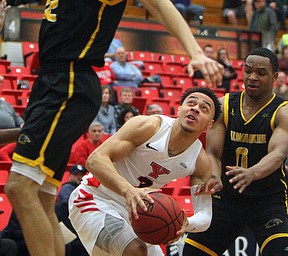 William D. Lewis The Vindicator YSU's Darius Quisenberry(3) drives around Milwaukee's Bryce Barnes(0) and Amir Allen(12) during 2-7-19 action at YSU.