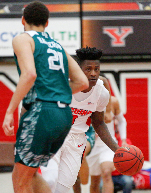 YSU's Donel Cathcart III dribbles the ball past Green Bay's Kameron Hankerson during their game in Beeghly Center on Saturday night. EMILY MATTHEWS | THE VINDICATOR