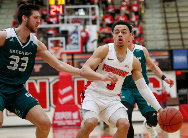 YSU's Darius Quisenberry dribbles the ball while Green Bay's Cody Schwartz tries to block him during their game in Beeghly Center on Saturday night. EMILY MATTHEWS | THE VINDICATOR