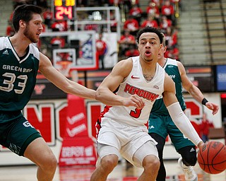 YSU's Darius Quisenberry dribbles the ball while Green Bay's Cody Schwartz tries to block him during their game in Beeghly Center on Saturday night. EMILY MATTHEWS | THE VINDICATOR