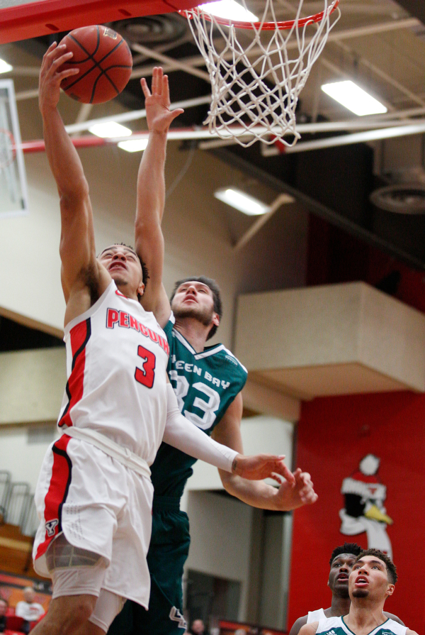YSU's Darius Quisenberry jumps for the hoop while Green Bay's Cody Schwartz tries to block him during their game in Beeghly Center on Saturday night. EMILY MATTHEWS | THE VINDICATOR