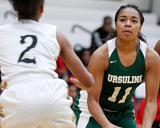 Ursuline's Dayshanette Harris looks toward the hoop while Warren G. Harding's Diamond Phillips tries to block her during their game at Warren G. Harding High School on Monday night. EMILY MATTHEWS | THE VINDICATOR