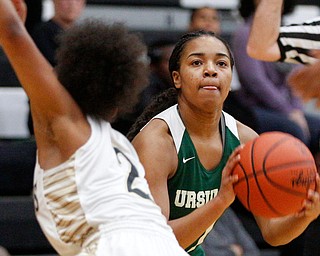 Ursuline's Dayshanette Harris looks toward the hoop while Warren G. Harding's Diamond Phillips tries to block her during their game at Warren G. Harding High School on Monday night. EMILY MATTHEWS | THE VINDICATOR