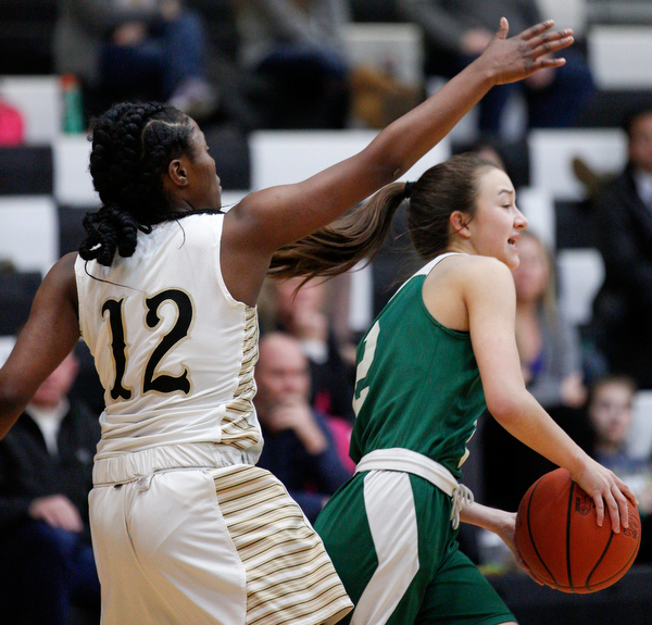 Ursuline's Rachel Fabry looks to pass the ball while Warren G. Harding's Kamarah Bender tries to block her during their game at Warren G. Harding High School on Monday night. EMILY MATTHEWS | THE VINDICATOR