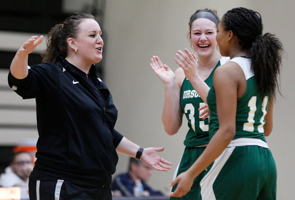 Ursuline's Coach Vannessa Dickson and Lindsay Bell, center, celebrate after Dayshanette Harris, right, breaks Ursuline's all-time scoring record of 2,297 points during their game against Warren G. Harding on Monday night. EMILY MATTHEWS | THE VINDICATOR