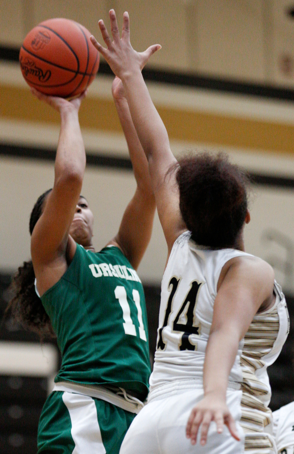 Ursuline's Dayshanette Harris shoots the ball while Warren G. Harding's Indea Phillips tries to block her during their game at Warren G. Harding High School on Monday night. EMILY MATTHEWS | THE VINDICATOR