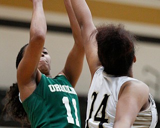 Ursuline's Dayshanette Harris shoots the ball while Warren G. Harding's Indea Phillips tries to block her during their game at Warren G. Harding High School on Monday night. EMILY MATTHEWS | THE VINDICATOR