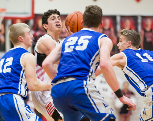 Canfield's Conor Crogan looks to shoot the ball while, from left, Lake's Cameron Martin, Jakob Maranville, and Bryce Snow try to block him during their game at Canfield High School on Tuesday night. EMILY MATTHEWS | THE VINDICATOR