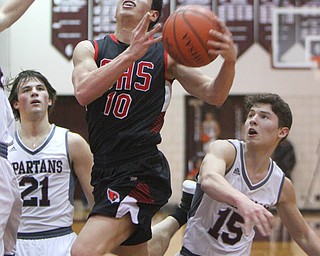 William D. Lewis The Vindicator Canfield's Conor Crogan (10) drives to the hoop past Boardman's Cam Kreps(21) and Nick Torres(15) during 2-15-19 action at Boardman.