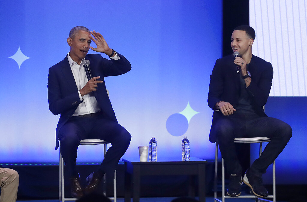 Former President Barack Obama, left, gestures as Golden State Warriors basketball player Stephen Curry laughs while speaking at the My Brother's Keeper Alliance Summit in Oakland, Calif., on Tuesday, Feb. 19, 2019.