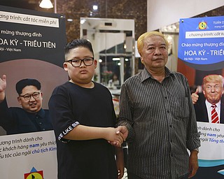 Le Phuc Hai, 66, and To Gia Huy, 9, pose for a photo after having Trump and Kim haircuts in Hanoi, Vietnam, on Tuesday, Feb. 19, 2019. U.S. President Donald Trump and North Korean leader Kim Jong Un have become the latest style icons in Hanoi, a week before their second summit is to be held in the capital city of Vietnam.