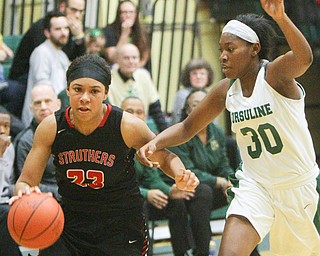 William D. Lewis The Vindicator   Struthers Trinity McDowell(23) drives around Ursuline's Anyah Curd(30).