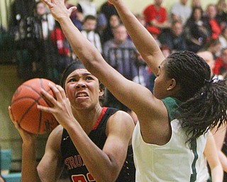 William D. Lewis The Vindicator   Struthers Trinity McDowell(23) shoots past Ursuline's Dayshanette Harris(1)..