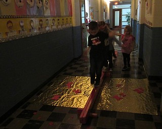Neighbors | Jessica Harker .Upon exiting Valentine Land, preschool students balanced their way across the golden sea, heading back to the "plane" that would take them back home on Feb. 14 at the Austintown Community Church Preschool and Childcare Center.