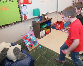 Neighbors | Jessica Harker.Kevin Coss played the bean bag toss game set up during Poland Union Elementary School's annual Valentine's Day celebration on Feb. 14.