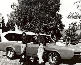 FILE - In this 1966 file photo, cast members of the television show "The Monkees," from top left, Davy Jones, Michael Nesmith, from lower left, Micky Dolenz, and Peter Tork pose next to their customized Pontiac GTO. Jones died Wednesday Feb. 29, 2012 in Florida. He was 66. Jones rose to fame in 1965 when he joined The Monkees, a British popular rock group formed for a television show. Jones sang lead vocals on songs like "I Wanna Be Free" and "Daydream Believer."    (AP Photo/File)