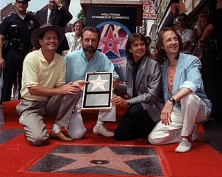 In this July 10, 1989 file photo, The Monkees, from left: Micky Dolenz, Mike Nesmith, Davy Jones and Peter Tork  get a star on the Hollywood Walk of Fame. (AP Photo/Mark Terrill)