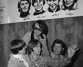 American pop band "The Monkees", are seen beneath a poster with sketches of themselves, during their press conference in London, England, Thursday June 29, 1967. They are from left to right: Davy Jones, Peter Tork, Mike Nesmith and Micky Dolenz.. The band arrived yesterday and will give their first concert tomorrow at the Empire Pool, here in London. (AP Photo/Eddie Worth)