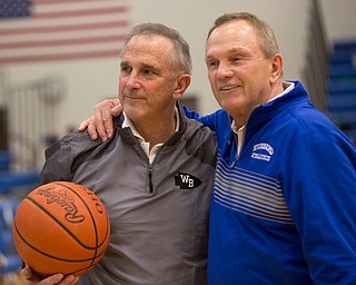 West Branch's Head Coach Randy Montgomery, left, received the game ball from his brother and Hubbard Athletic Director Chuck Montgomery after his 600th victory during their game at Hubbard on Friday night. EMILY MATTHEWS | THE VINDICATOR