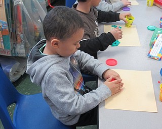 Neighbors | Jessica Harker.Robinwood Elementary School student Asodbek Alisherov worked with playdough to spell his name accompanied by high school students from Boardman High School on Feb. 1 for the Big Spartan Little Spartan program.