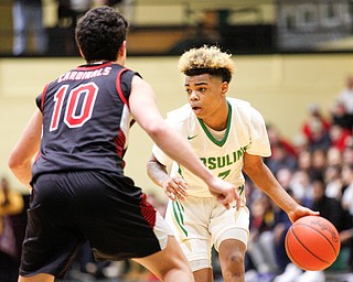 Ursuline's Daysean Harris drives the ball while Canfield's Conor Crogan tries to block him during their game at Ursuline on Friday night. EMILY MATTHEWS | THE VINDICATOR