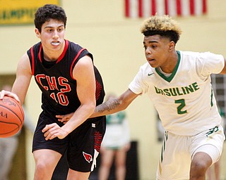 Canfield's Conor Crogan drives the ball while Ursuline's Daysean Harris tries to block him during their game at Ursuline on Friday night. EMILY MATTHEWS | THE VINDICATOR