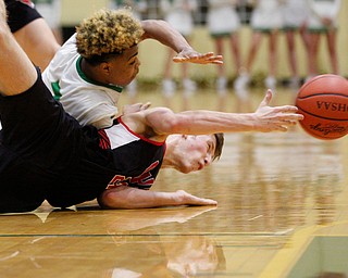 Canfield's Kyle Gamble and Ursuline's Daysean Harris reach for the ball during their game at Ursuline on Friday night. EMILY MATTHEWS | THE VINDICATOR