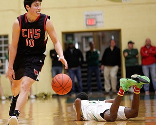 Canfield's Conor Crogan drives the ball after Ursuline's Jakylan Irving falls to the ground during their game at Ursuline on Friday night. EMILY MATTHEWS | THE VINDICATOR