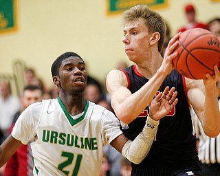 Canfield's Aydin Hanousek looks to pass the ball while Ursuline's RJ Clark tries to block him during their game at Ursuline on Friday night. EMILY MATTHEWS | THE VINDICATOR