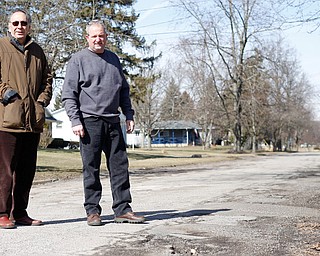 Liberty Township trustees Arnie Clebone, left, and Greg Cizmar stand on Fifth Avenue Extension, one of the township roads scheduled to be resurfaced this year. Residents approved a road levy last year that allows the township to pave more roads annually.