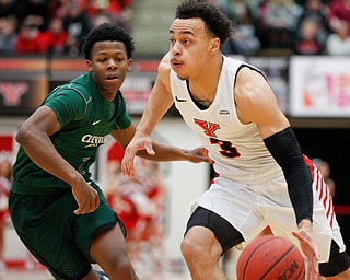 YSU's Darius Quisenberry drives the ball while CSU's Tyree Appleby runs after him during their game on Saturday night. EMILY MATTHEWS | THE VINDICATOR