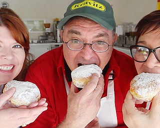 Plaza Donuts owner Amy Spencer, left, Kravitz Deli owner Jack Kravitz and Polish Youngstown director Aundrea Cika Heschmeyer eat fresh paczki. Plaza Donuts will make about 3,000 of the Polish-style doughnuts.
