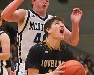 William D. Lewis The vindicator Lowellville's Matt Hvisdak(14) shoots past McDonald's Jake Portolese(40).