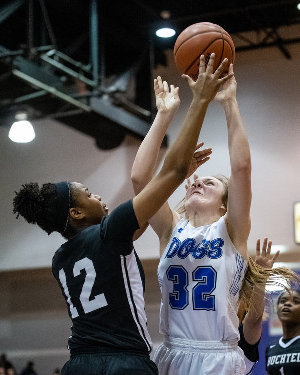 DIANNA OATRIDGE | THE VINDICATOR  Poland's Morgan Kluchar (32) puts up a shot as Akron Buchtel's Kanai Chance (12) defends during the Division II Girls Regional Semi-final in Barberton on Tueday.