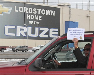 William D. Lewis the vindictor   Greg Hicks, Warren Law Ditecotr holds a sign as he drives by the GM plant 3-6-19.