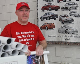 William D. Lewis the vindictor  John Davies an 11 year Lordstown GM worker folds posters of cars produced at the plant. The UAW will distribute the posters during St PAt's parade.