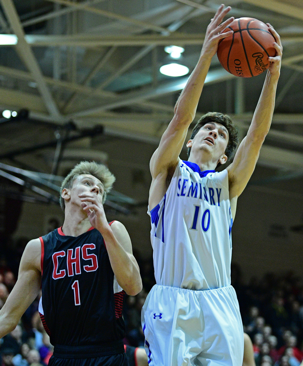 BOARDMAN, OHIO - MARCH 6, 2019: Poland's Daniel Kramer grabs a rebound away from Canfield's Aydin Hanousek during the first half of their OHSAA Tournament game, Wednesday night at Boardman High School. DAVID DERMER | THE VINDICATOR