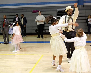 James Bevely dances with his daughters Galaiah Bevely, 10, left, and Ja'lisa Bevely, 7, all of Youngstown, during the Youngstown City School District father-daughter dance at East High School on Friday night. EMILY MATTHEWS | THE VINDICATOR