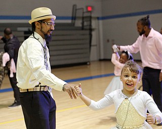 James Bevely dances with his daughter Ja'lisa Bevely, 7, both of Youngstown, during the Youngstown City School District father-daughter dance at East High School on Friday night. EMILY MATTHEWS | THE VINDICATOR