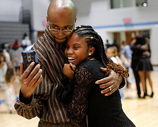 Corey Jolliff takes a photo with his daughter Jaylaysha Jolliff, 14, both of Youngstown, during the Youngstown City School District father-daughter dance at East High School on Friday night. EMILY MATTHEWS | THE VINDICATOR