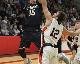 Jake Rotz (15) of Lowellville goes up for a shot while being defended by Shane Eynon (12) of Springfield during Friday nights district championship game at Struthers High School.  Dustin Livesay  |  The Vindicator  3/8/19  Struthers