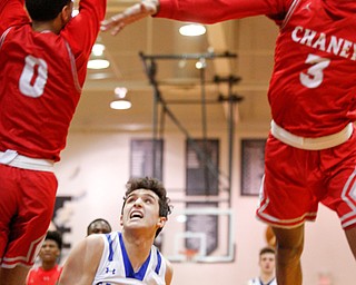 Poland's Adam Kassem looks to the hoop while Chaney's Sharrod Taylor (0) and Marquel Gillespie (3) try to block him during their game at Boardman High School on Saturday. EMILY MATTHEWS | THE VINDICATOR