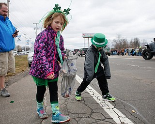 Siblings Nora McMasters, 6, and Liams McMasters, 4, of Austintown, pick up candy as they watch the Mahoning Valley St. Patrick's Day Parade with their dad Ryan McMasters in Boardman on Sunday afternoon. Nora and Liam's younger brother Grant, 2, and mom Heather McMasters were watching from their car. EMILY MATTHEWS | THE VINDICATOR